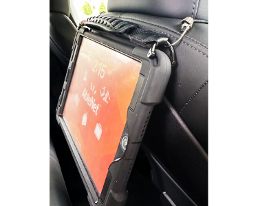 A side view of a QuickTalker Freestyle attached to the back of a car seat headrest with a bungee cord!