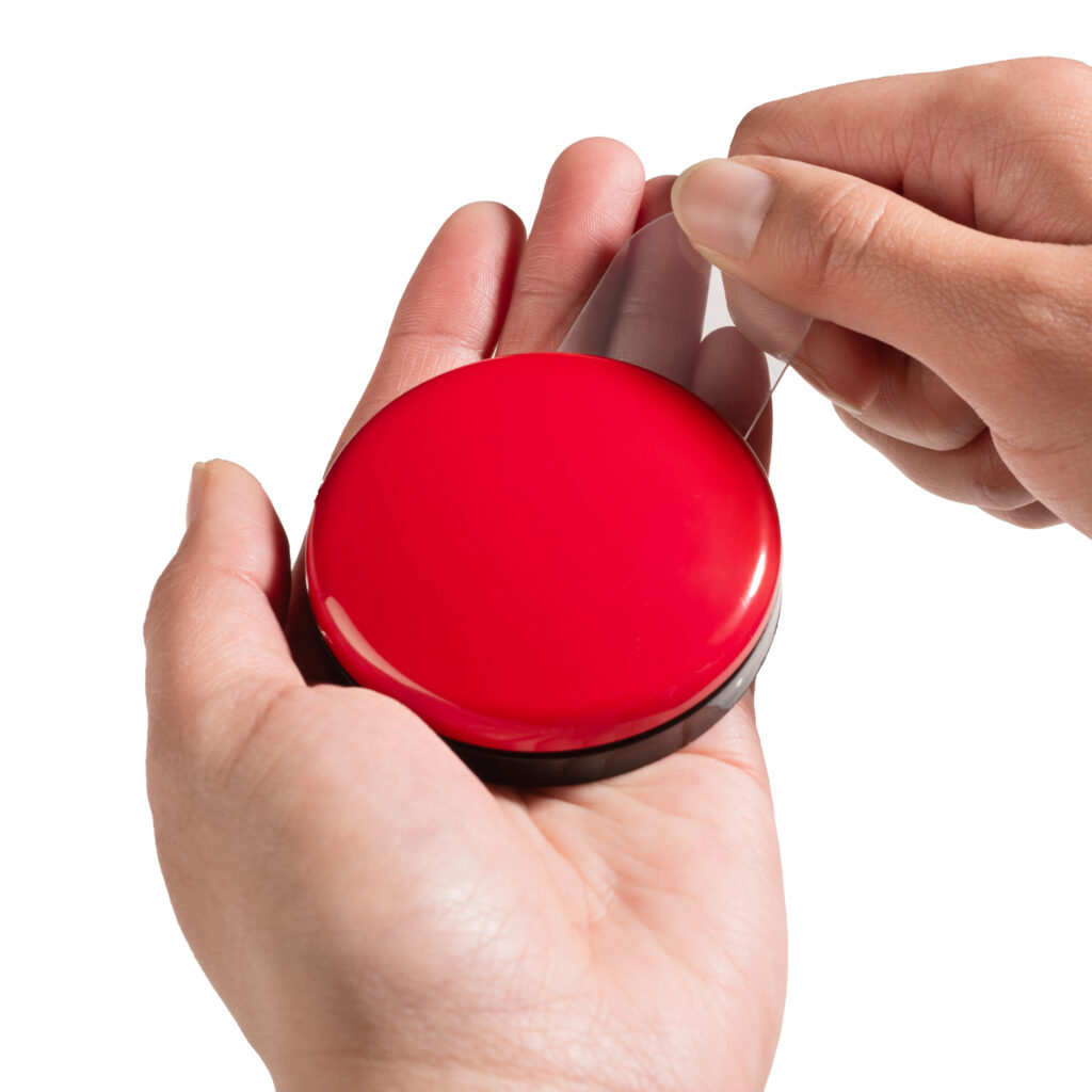 Person using release tool on Buddy Button IC tab while rotating red switch cap