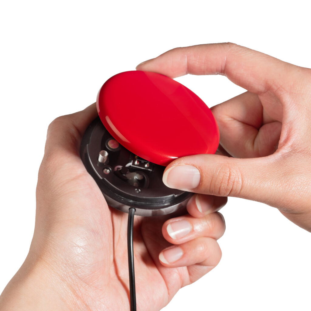 Person changing interchangeable switch top on Buddy Button IC adaptive switch