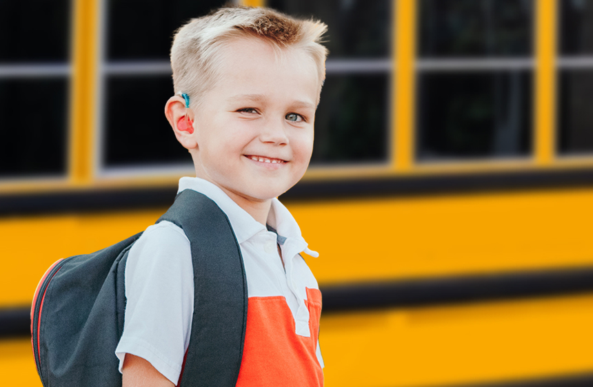 boy standing next to a school bus