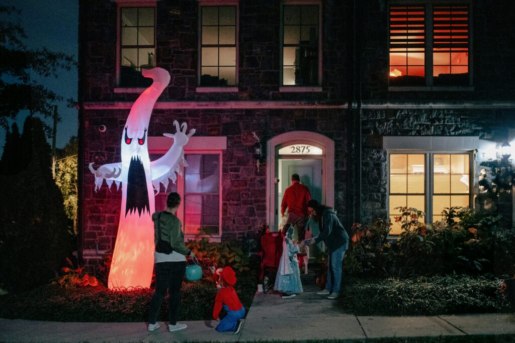 Family Trick or Treating at a house with spooky decor