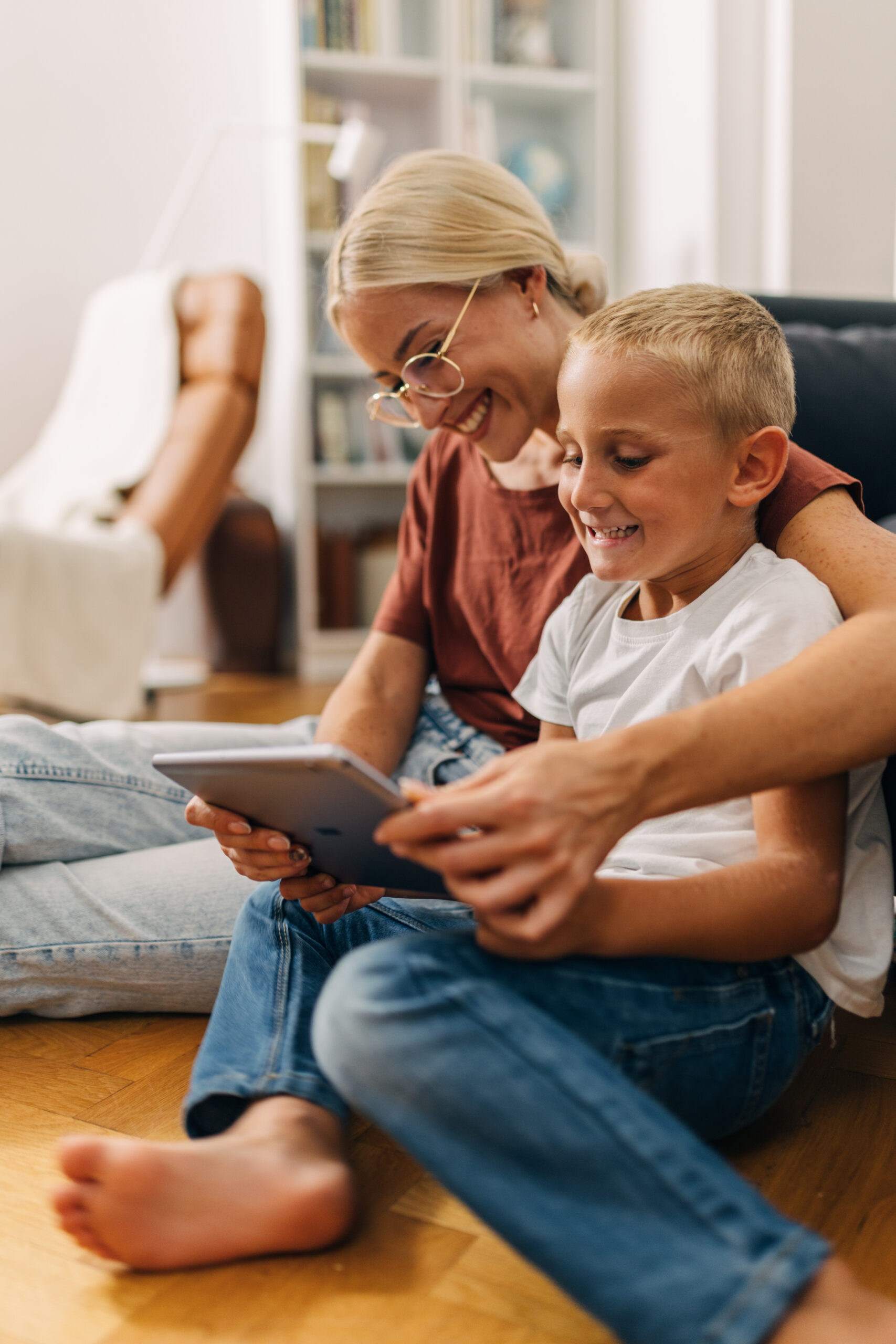 Mother and son playing a video game together using tablet.