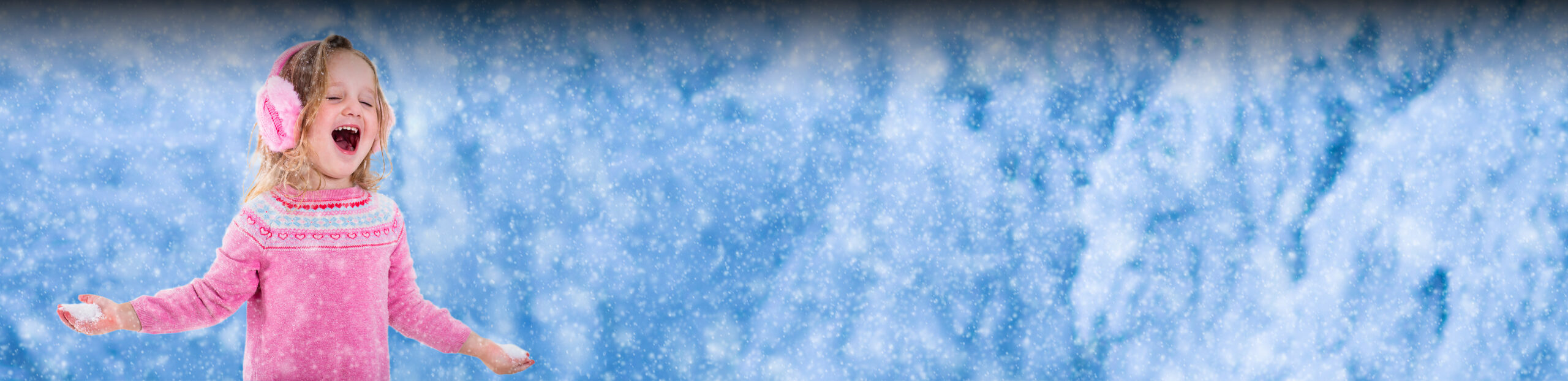 Young girl in pink enjoying a light dusting of snow outside